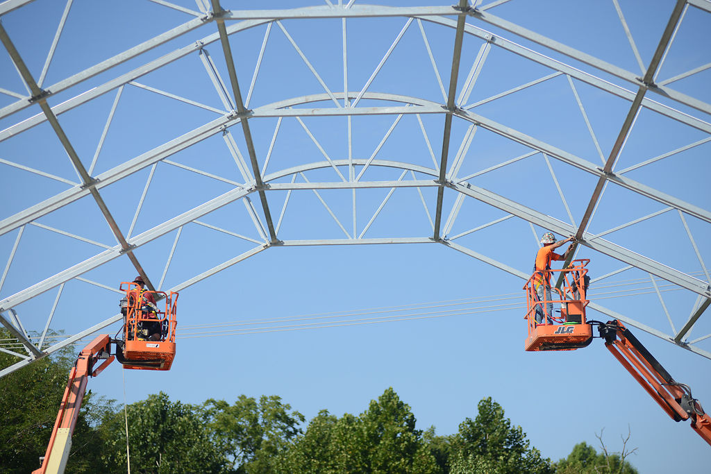Construction workers Adam Rowell, left and John Oakley work on the frame of the roof of new building for the Columbia Canine Sports Center on Thursday